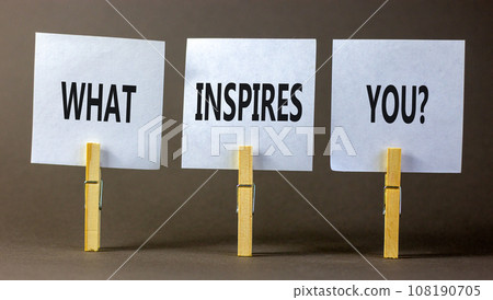 What inspires you symbol. Concept words What inspires you on beautiful white paper on clothespin. Beautiful grey background. Business motivational what inspires you concept. Copy space. 108190705