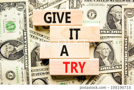 Give it a try symbol. Concept word Give it a try on beautiful wooden block. Dollar bills. Beautiful background from dollar bills. Business give it a try concept. Copy space. 108190718