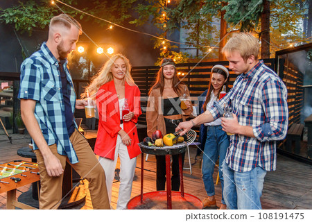 Friends having barbecue party in the backyard of the house. 108191475
