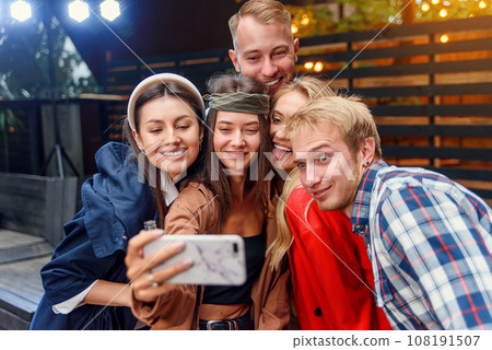 Happy four friends watching internet social media in cell phone. Every one with his own phone Happy four friends watching internet social media in cell phone. Every one with his own phone 108191507
