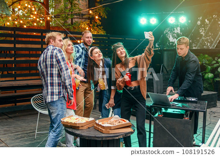 Pretty young women and handsome guys at celebration party making selfie photo on smartphone. Pretty young women and handsome guys at celebration party making selfie photo on smartphone. 108191526