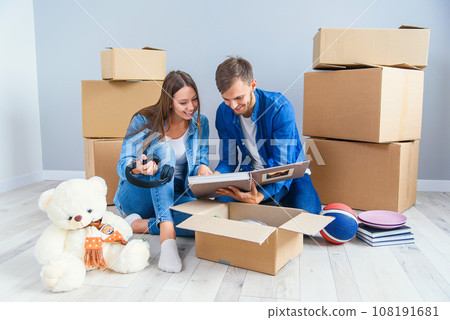 Young couple unpacking things after moving into new house Young couple unpacking things after moving into new house 108191681