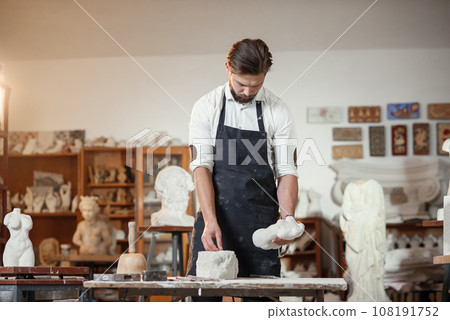 Bearded sculptor measures stone woman torso to make copy of it from limestone at creative studio. 108191752