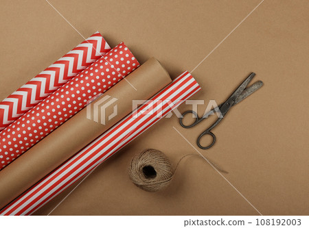 Packing Christmas gifts with red and brown paper 108192003