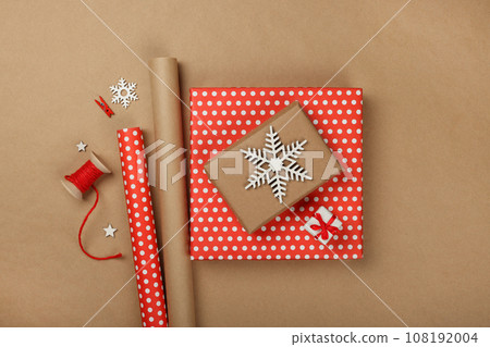 Packing Christmas gifts with red paper 108192004