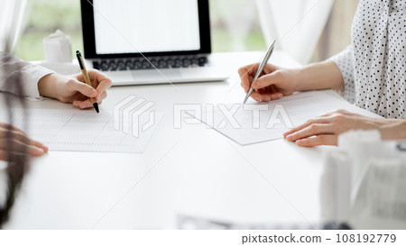 Two accountants using a laptop computer for counting taxes at white desk in office. Teamwork in business audit and finance 108192779
