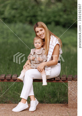 Young european woman in casual clothes with a small child Young european woman in casual clothes with a small child 108192807