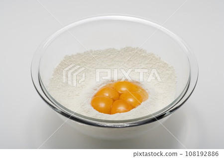 Bowl of flour and egg yolk. Bowl of flour and egg yolk. 108192886