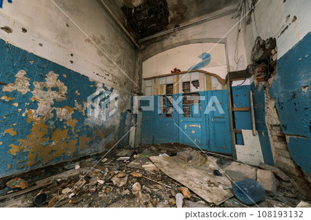 From above interior of dirty peeling paint walls with broken ceiling wooden furniture on heap of strewn rubble on floor and cracked concrete construction room in daylight From above interior of dirty peeling paint walls with broken ceiling wooden furniture on heap of strewn rubble on floor and cracked concrete construction room in daylight 108193132