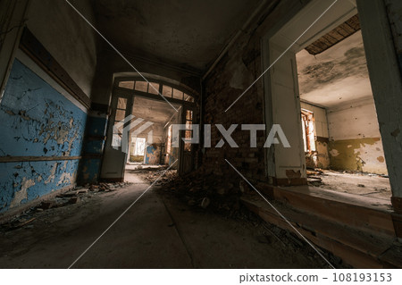 From above of abandoned building dwelling residential place with shabby dirty walls spacious rooms in daylight from windows and rubble strewn floors with arched decorated glass doorway 108193153