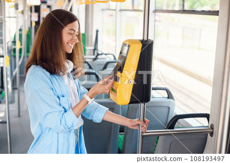 Female traveler pays contactless with bank card for the public transport in the tram or subway. 108193497