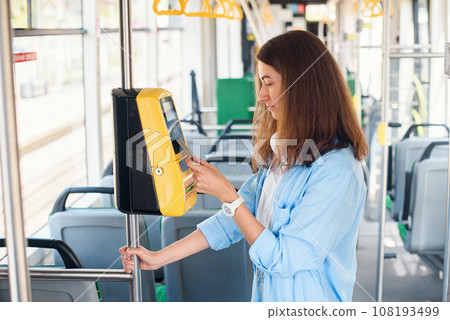 Young woman pays by bank card for the public transport in the tram or subway. 108193499