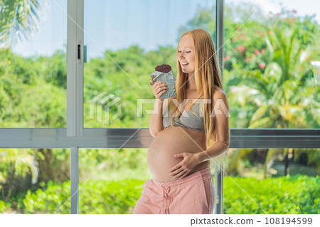 Capturing a pregnant woman enjoying chocolate, exploring the sweet indulgence during pregnancy, highlighting the delightful moments and potential effects of chocolate Capturing a pregnant woman enjoying chocolate, exploring the sweet indulgence during pregnancy, highlighting the delightful moments and potential effects of chocolate 108194599
