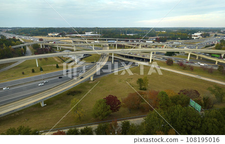 American freeway intersection with fast driving cars and trucks. View from above of USA transportation infrastructure 108195016