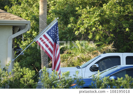 American flag waving on the corner of private residential house, symbol of patriotism 108195018