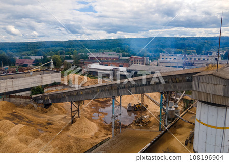 Aerial view of wood processing plant with smokestack from production process polluting environment at factory manufacturing yard Aerial view of wood processing plant with smokestack from production process polluting environment at factory manufacturing yard 108196904