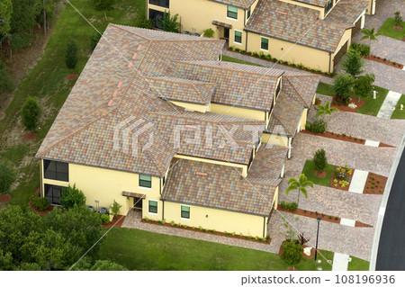 Aerial view of typical contemporary american private house with roof top covered with ceramic shingles and double garage Aerial view of typical contemporary american private house with roof top covered with ceramic shingles and double garage 108196936