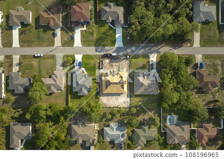 Aerial view of suburban private house wit wooden roof frame under construction in Florida quiet rural area 108196965