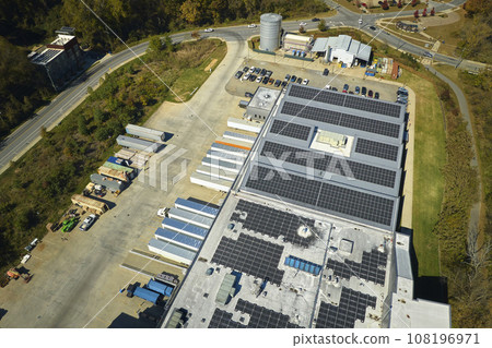 Aerial view of solar power plant with blue photovoltaic panels mounted on industrial building roof for producing green ecological electricity. Production of sustainable energy concept 108196971