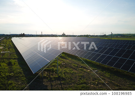 Aerial view of solar power plant on green field. Electric farm with panels for producing clean ecologic energy 108196985