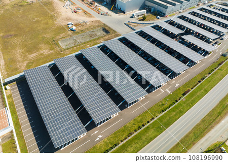 Aerial view of solar panels installed as shade roof over parking lot with parked cars for effective generation of clean electricity. Photovoltaic technology integrated in urban infrastructure 108196990