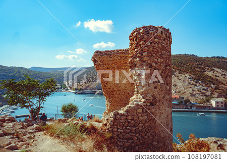 an ancient stone tower on a blue sky background 108197081