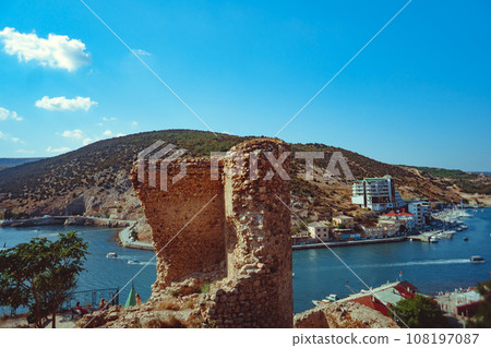 an ancient stone tower on a blue sky background 108197087