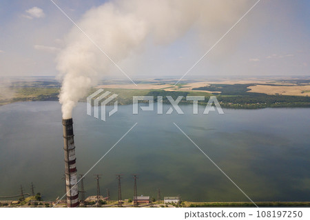 Aerial view of high chimney pipes with grey smoke from coal power plant. Production of electricity with fossil fuel. Aerial view of high chimney pipes with grey smoke from coal power plant. Production of electricity with fossil fuel. 108197250