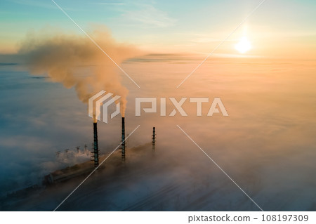 Aerial view of coal power plant high pipes with black smoke moving up polluting atmosphere at sunset. Aerial view of coal power plant high pipes with black smoke moving up polluting atmosphere at sunset. 108197309