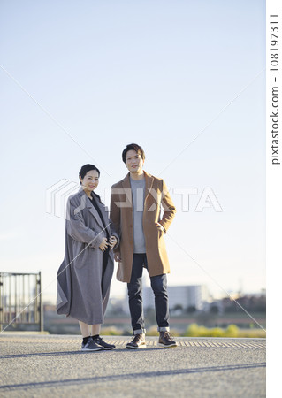Pregnant woman and man walking in the park at sunset 108197311
