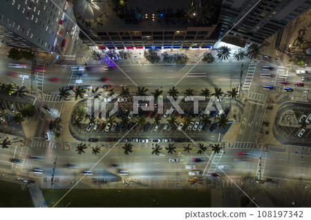 Aerial view of brightly illuminated street in downtown district of Miami city in Florida, USA. Traffic in modern american midtown Aerial view of brightly illuminated street in downtown district of Miami city in Florida, USA. Traffic in modern american midtown 108197342