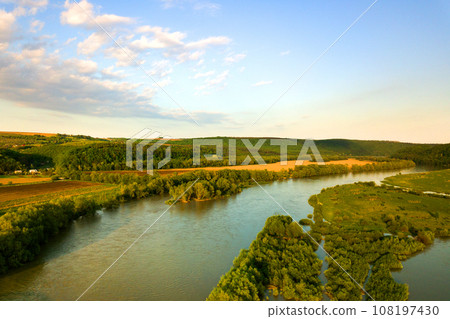 Aerial view of bright river flowing through green meadows in spring. 108197430