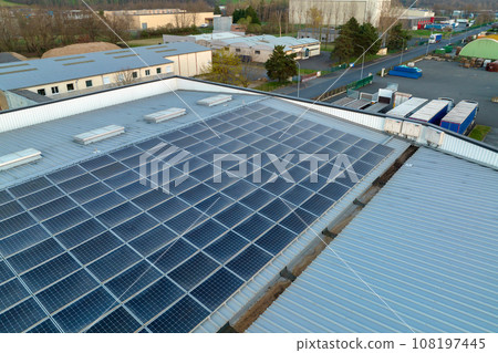 Aerial view of blue photovoltaic solar panels mounted on industrial building roof for producing green ecological electricity. Production of sustainable energy concept 108197445
