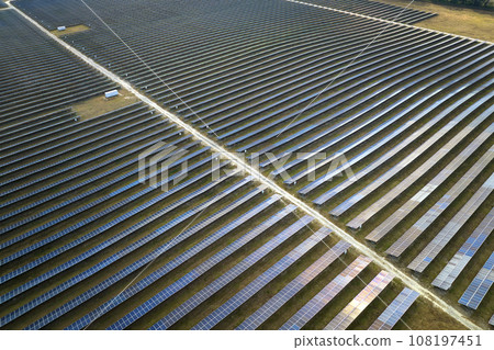 Aerial view of big sustainable electric power plant with many rows of solar photovoltaic panels for producing clean electrical energy. Renewable electricity with zero emission concept Aerial view of big sustainable electric power plant with many rows of solar photovoltaic panels for producing clean electrical energy. Renewable electricity with zero emission concept 108197451