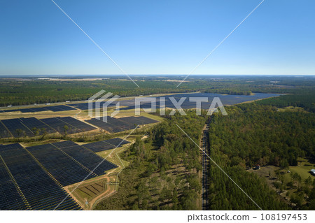 Aerial view of big sustainable electric power plant with many rows of solar photovoltaic panels for producing clean electrical energy. Renewable electricity with zero emission concept 108197453