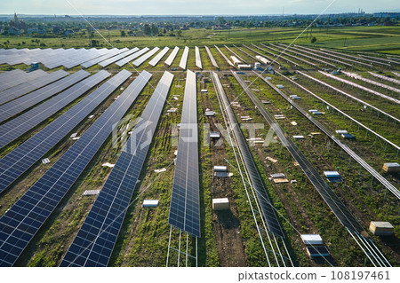 Aerial view of big electric power plant under construction with many rows of solar panels on metal frame for producing clean electrical energy. Development of renewable electricity sources 108197461