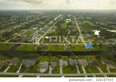 Aerial landscape view of suburban private houses between green palm trees in Florida quiet rural area Aerial landscape view of suburban private houses between green palm trees in Florida quiet rural area 108197543
