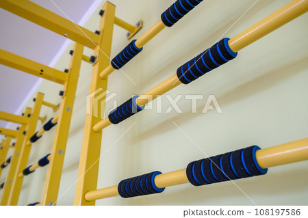 A wall with ladder bar for fitness training inside sports gym room in a school. 108197586