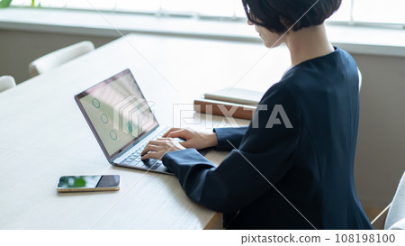 Woman using a laptop Woman using a laptop 108198100