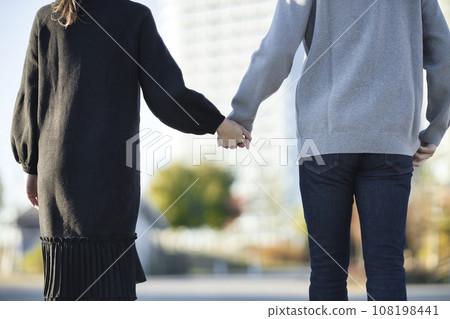 一名孕婦和一名男子手牽手在公園散步的後視圖 一名孕婦和一名男子手牽手在公園散步的後視圖 108198441