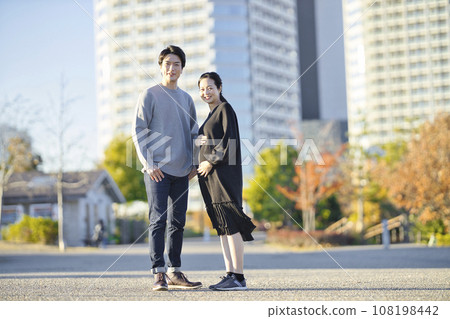 孕婦和男人手牽手在公園散步 孕婦和男人手牽手在公園散步 108198442