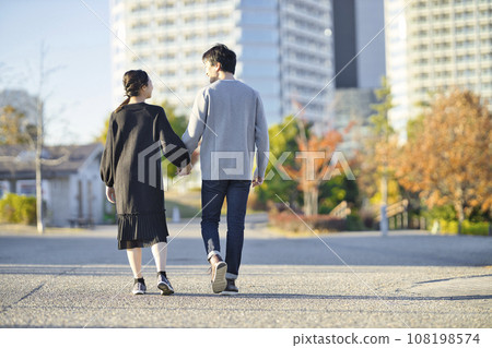 一名孕婦和一名男子手牽手在公園散步的後視圖 一名孕婦和一名男子手牽手在公園散步的後視圖 108198574