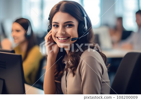 Call center operators with a small modern wireless headsets works with a desktop in an office 108200009