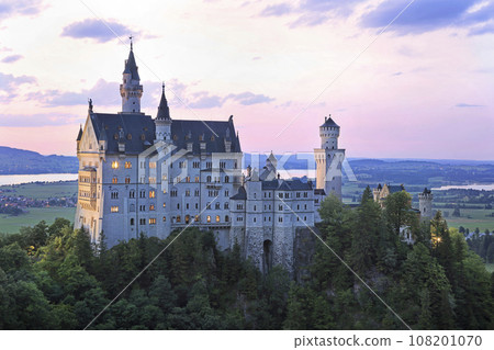 Aerial view of Neuschwanstein Castle with teenager hiking girl on the foreground 108201070