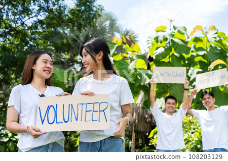 Happy young Asian students diverse volunteers hold a campaign sign for cleaning in the park, The concept of environmental conservation on world environment day, recycling, charity for sustainability. 108203129