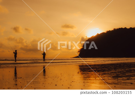 Layan Beach, Phuket, Thailand,Silhouette  Asian man standing fishing at the sea as the sun sets, 108203155