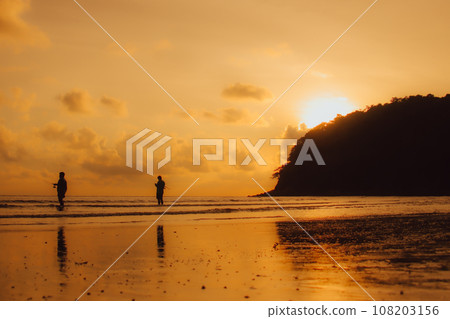 Layan Beach, Phuket, Thailand,Silhouette  Asian man standing fishing at the sea as the sun sets, 108203156