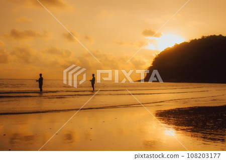 Layan Beach, Phuket, Thailand,Silhouette Asian man standing fishing at the sea as the sun sets, Layan Beach, Phuket, Thailand,Silhouette Asian man standing fishing at the sea as the sun sets, 108203177