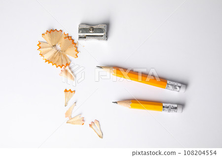 Short graphite pencils, shavings and sharpener on white background, top view 108204554