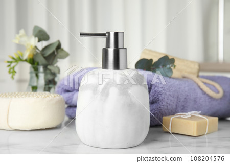 Soap dispenser and toiletries on white marble table 108204576